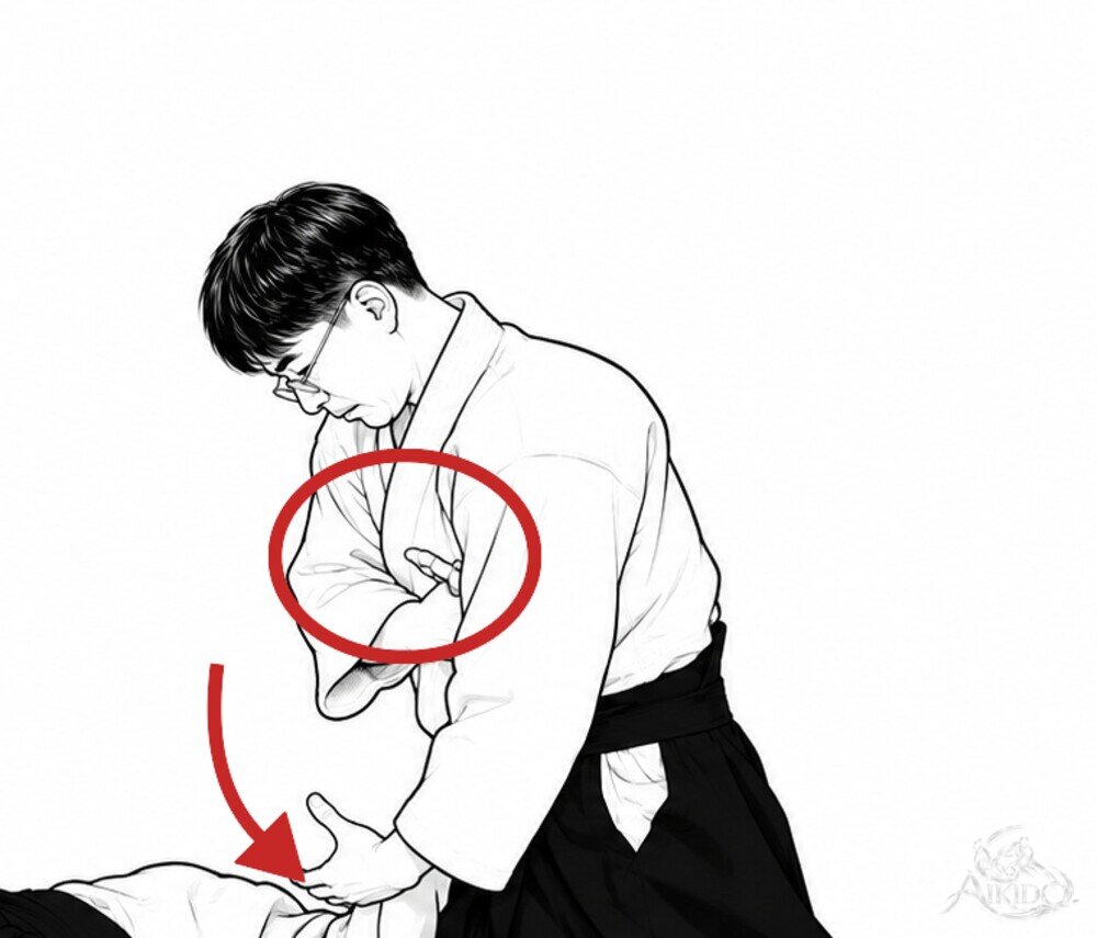손을 다시 고쳐 잡아 제압한다 — 2. 비튼 손목을 어깨 앞에 붙이고 왼팔로 이끌며 제압한다.